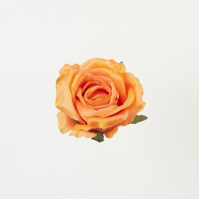 Oranssi tekoruusun pää vihreällä tyvellä