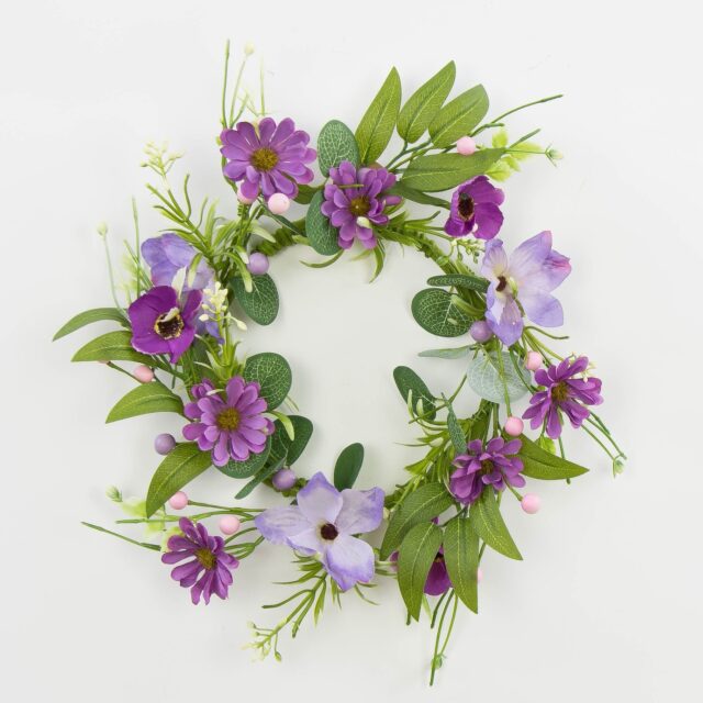 Violetti tekokukkaseppele vihreillä lehdillä