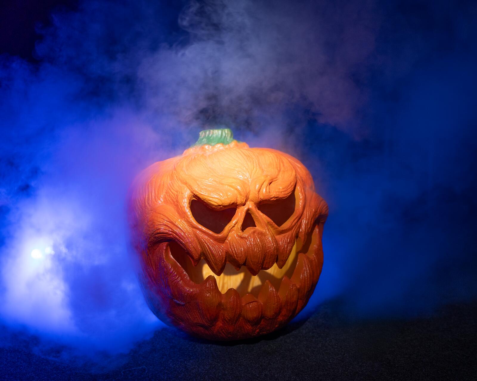 Oranssi valaistu Halloween-kurpitsa kasvokuvioinnilla