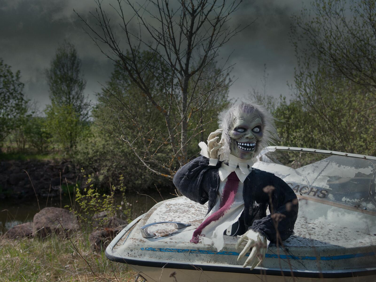 Animoitu harmaa zombivartalo mustassa takissa ja punaisessa solmiossa