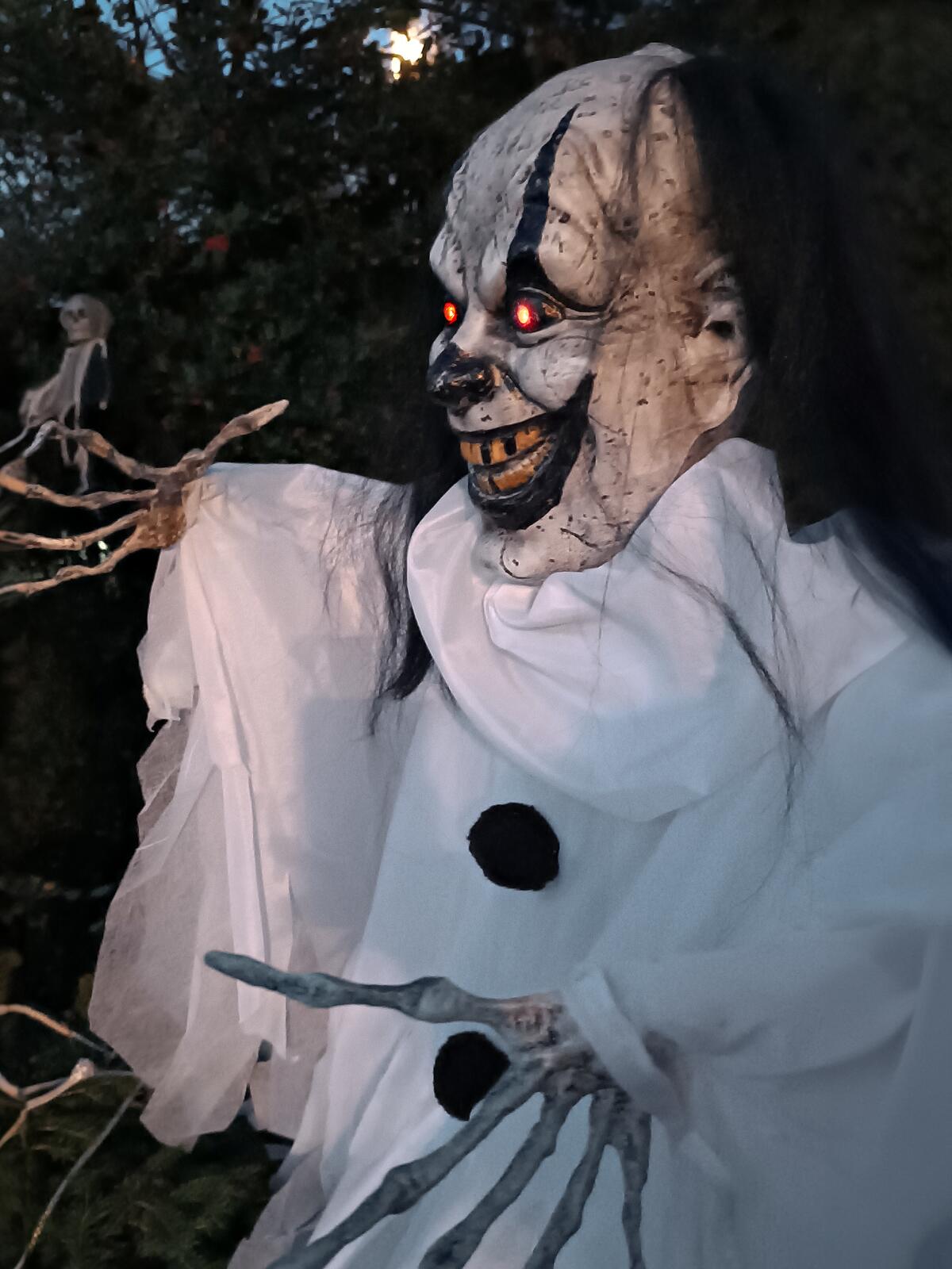 Valkoiseen repaleiseen asuun pukeutunut animoitu Halloween-klovnihahmo