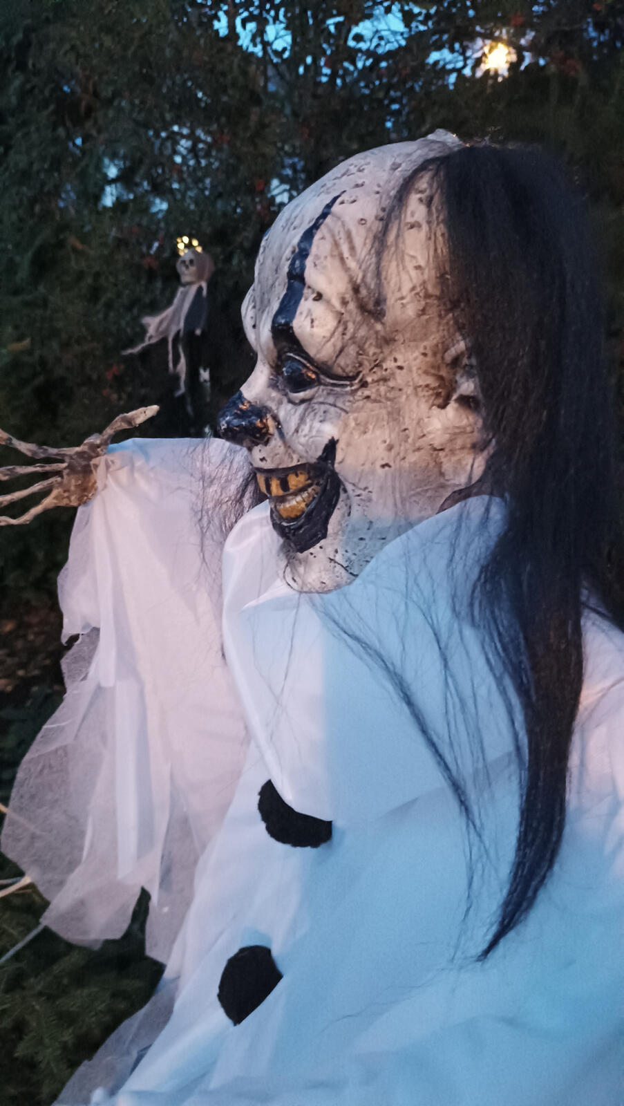Valkoiseen repaleiseen asuun pukeutunut animoitu Halloween-klovnihahmo