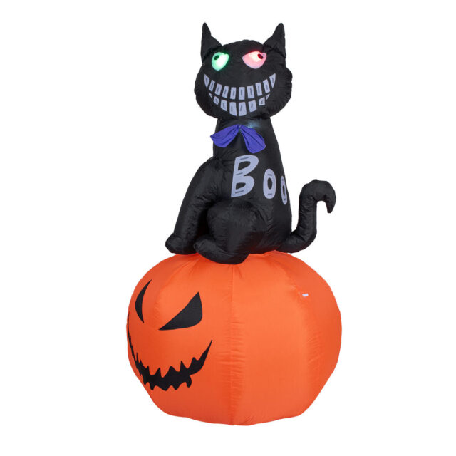 Ilmatäytteinen musta Halloween-kissa oranssin kurpitsan päällä
