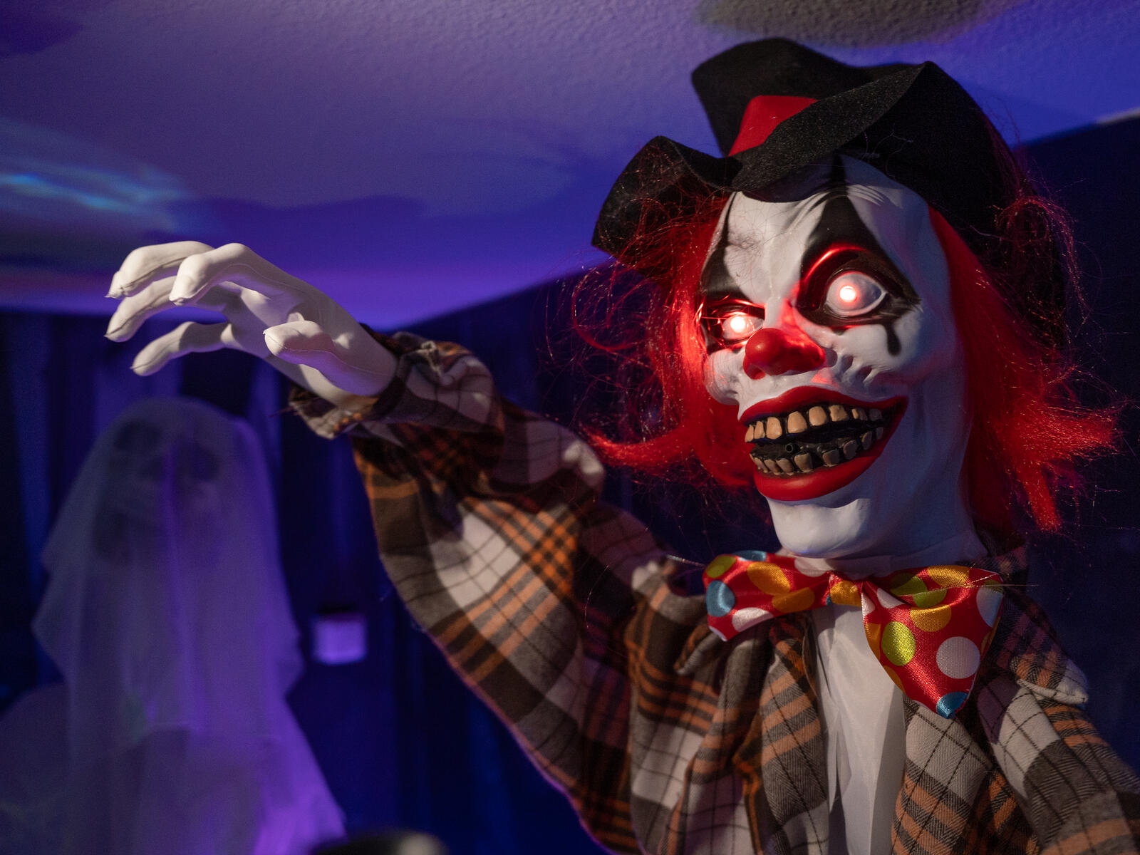 Animoitu Halloween-klovnihahmo mustassa hatussa ja ruudullisessa takissa